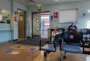 doctors office with social ditancing signage to not sit in certain chairs