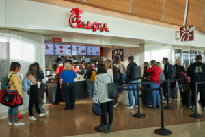 chick fil a signs and people waiting in line at a mall