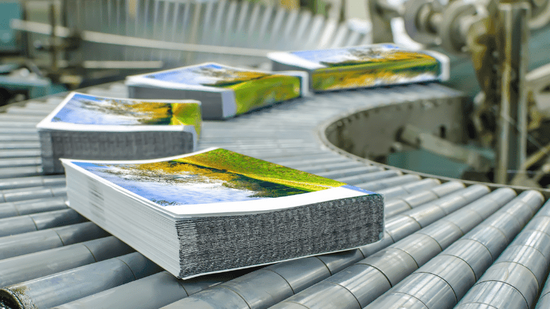 books on a rolling conveyer rack at a printer