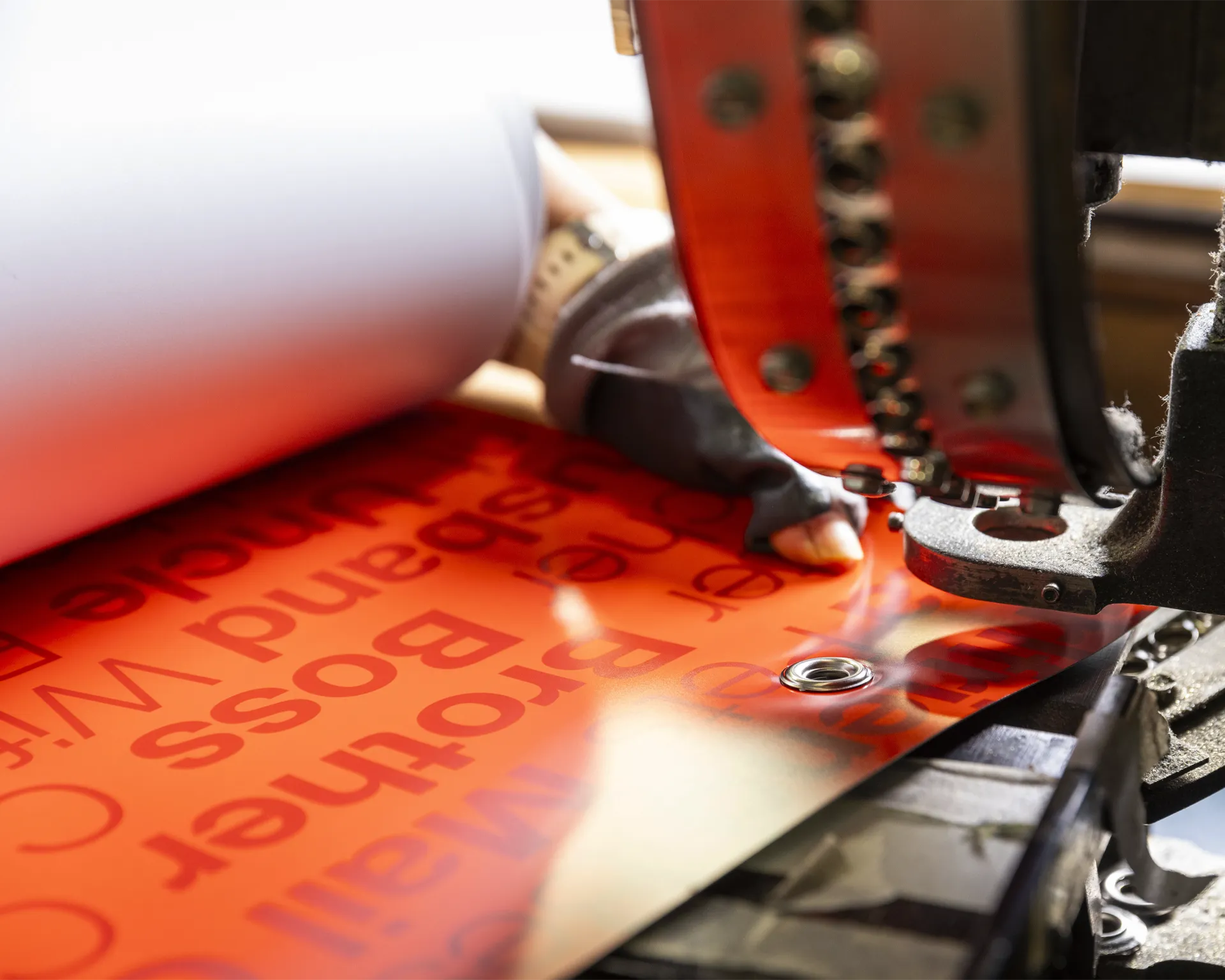 Closeup of a grommeting machine being used on a vinyl banner