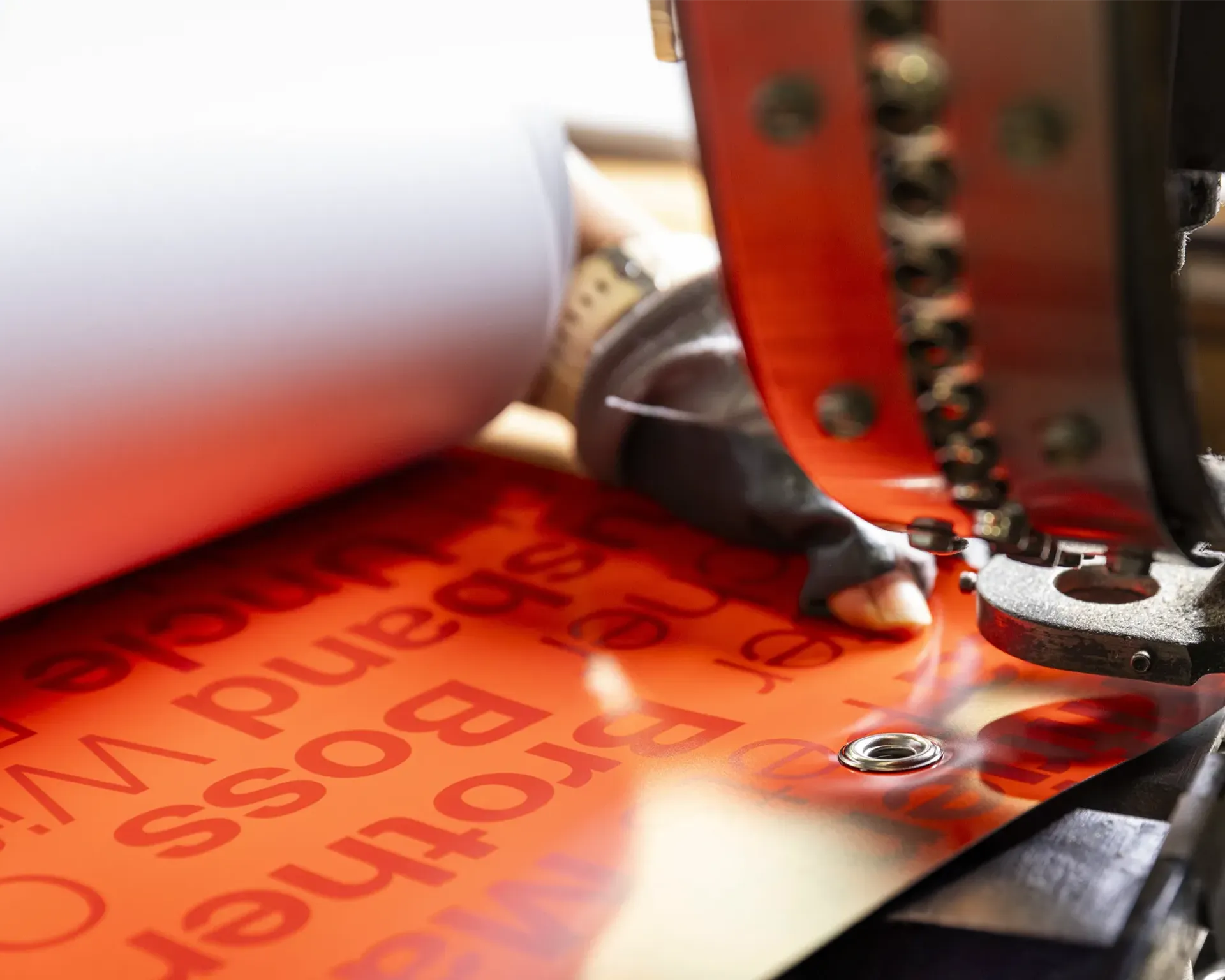 Closeup of a grommeting machine being used on a vinyl banner